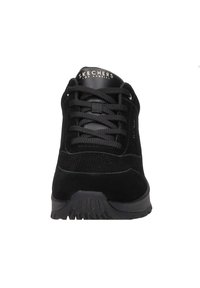 Czarny but sportowy z teksturowanym zamszowym wierzchem, okrągłym noskiem i płaskimi sznurówkami. Posiada gumową podeszwę z rowkami antypoślizgowymi oraz logo na języku.