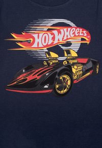 Maglietta nera con un vivace grafico di una macchina da corsa, con fiamme rosse e gialle, grandi motori e accenti dorati su uno sfondo scuro.