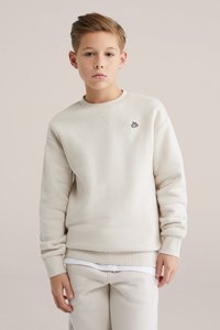 Bluza bej din material moale, cu guler rotund, manșete din rib și un logo mic negru brodat pe piept.