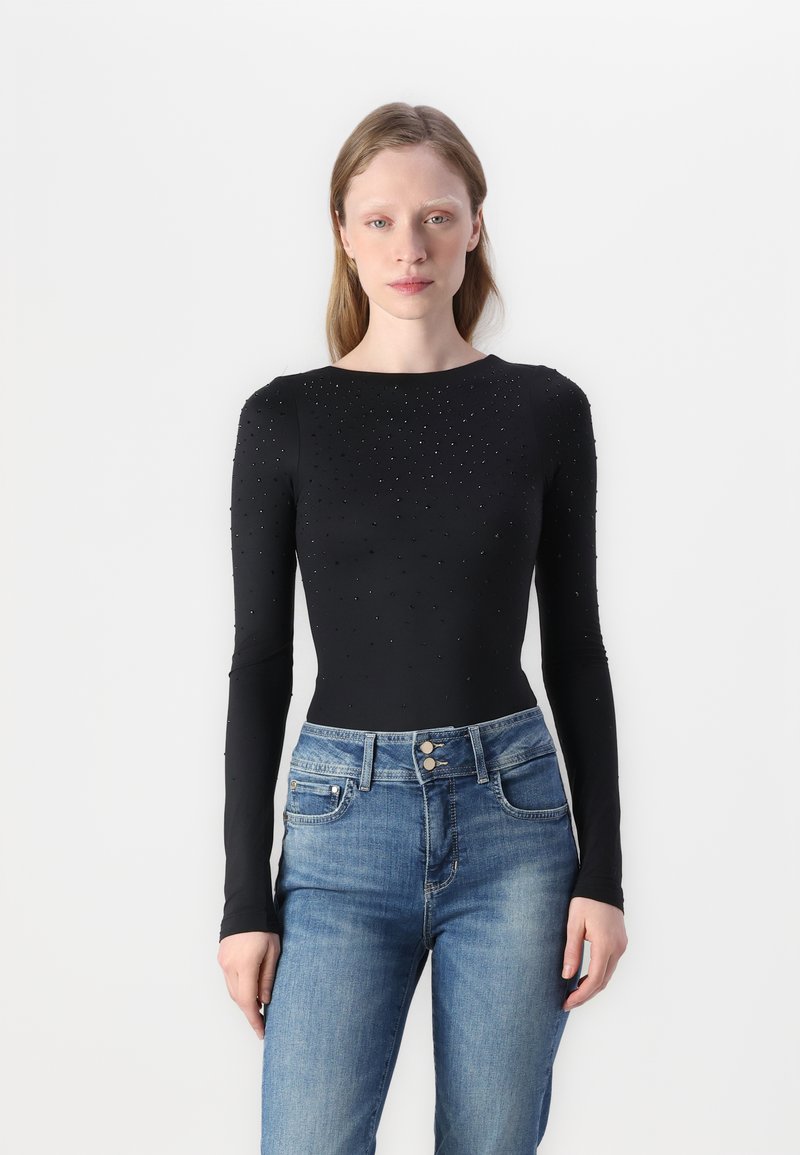 Black long-sleeve bodysuit with a smooth texture, featuring small, evenly spaced embellishments. Paired with light blue denim jeans.