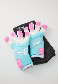 Pair of turquoise and pink goalkeeper gloves with Puma logo resting on black glove bag labeled "Future Goalkeeper Gloves."