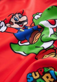 Tessuto rosso con una texture liscia, caratterizzato da una stampa colorata di Mario e Yoshi. Il design include contorni audaci e accenti vibranti di blu, verde e giallo.
