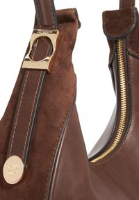 Bruine leren en suède handtas met een gouden hardware accent en ritsdetail, met contrasterende stiksel langs de banden.