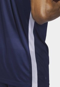 Dunkelblaues Sportshirt mit weißen Netzseitepanelen, glatter Textur, kurzen Ärmeln und abgerundetem Saum. Das Design betont die Atmungsaktivität.