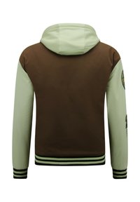 Hooded jacket met een bruine body en mintgroene mouwen. Inclusief gestreepte manchetten en een logo patch op de linkermouw. Soepele textuur.