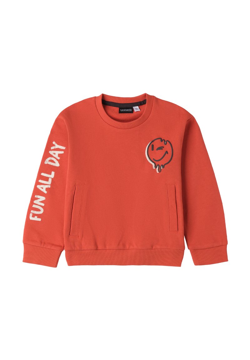 Felpa arancione con collo a giro e polsini a costine. Presenta una grafica di un volto sorridente e la scritta "DIVERTIMENTO TUTTO IL GIORNO" sulla manica. Due tasche laterali.