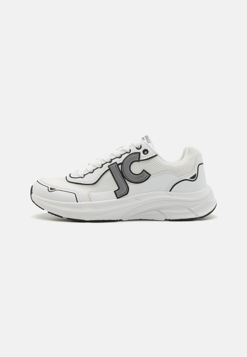 Weißer Sportschuh mit schwarzen Akzenten, Obermaterial aus Mesh, strukturierte Gummisohle und prominentem "JC"-Logo an der Seite. Flaches Design.