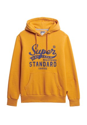 Geel hoodie van zacht materiaal, met een voorzak in kangoeroestijl, een capuchon met trekkoord en bedrukt tekst in marineblauw.