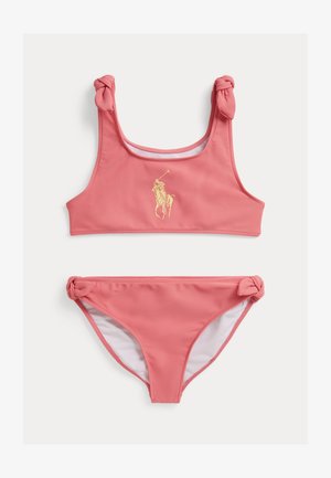Set de bikini roz format dintr-un top cu bretele înnodate și un logo auriu, și slip asortat cu accente înnodate pe laterale.