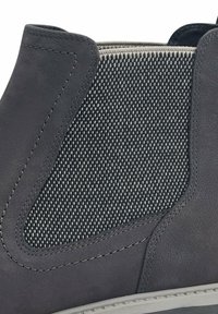 Grauer Knöchelstiefel mit einer glatten Lederaußenseite und einem strukturierten Mesh-Seitenpanel. Kontrastnähte entlang der Ränder und eine flexible Sohle.