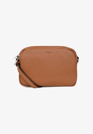 Brown leather crossbody bag with a smooth texture, rectangular shape, zip closure, and adjustable strap. Features embossed brand logo on front.