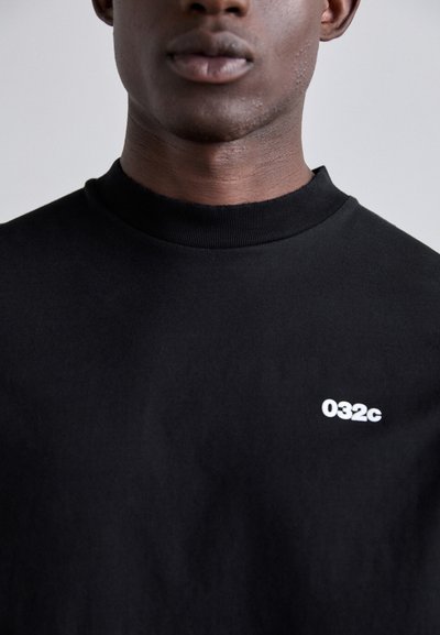 Black cotton sweatshirt with a high collar, featuring a small white "032c" logo on the left side. Smooth texture, minimalist design.