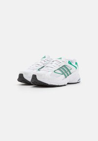 Scarpe da ginnastica bianche con accenti verdi. Parte superiore in rete con sovrapposizioni sintetiche, sistema di allacciatura e suola in gomma testurizzata. Tallone imbottito per il comfort.