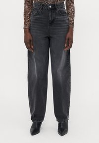 High-waisted black denim jeans with a loose fit, subtle fading, front pockets, and stitched detailing at the waistband and hem.