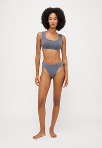 Grå, räfflad tvådelad set som består av en crop top med fyrkantig halsringning och låg midja på trosan. Mjuktyg med smooth yta, minimalistisk design.
