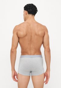 Boxers en coton gris avec une ceinture grise lisse, design ajusté et coutures plates. Le tissu a une texture douce et un minimum de détails.