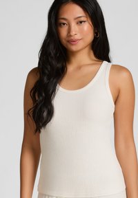 Geribbelde witte tanktop met een ronde halslijn en brede schouderbanden. Gemaakt van een zachte stof, met een getailleerde snit en een gladde textuur.