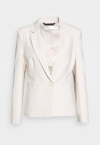 Blazer beige clair avec un col cranté, fermeture à un bouton et une coupe ajustée aux lignes épurées. Le matériau semble lisse et structuré.