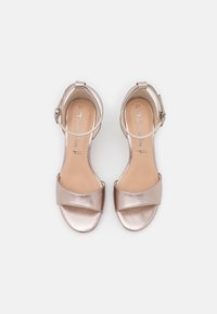 Metalliska roséguld högklackade sandaler med ett brett framband, ankelrem och en slät, fin yta. Storlek 37.