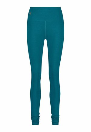 Türkisblaue Leggings mit figurbetontem Design, gefertigt aus weichem, elastischem Stoff. Verfügt über einen breiten Bund und geraffte Details am Knöchel.