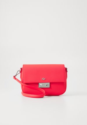 Sac bandoulière rose vif avec une finition texturée, fermoir en métal argenté et sangle réglable. Présente un logo sur le devant.