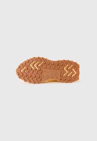 Rubber sole of a Lacoste shoe with zigzag tread pattern and embossed logo, displayed on a plain white background.