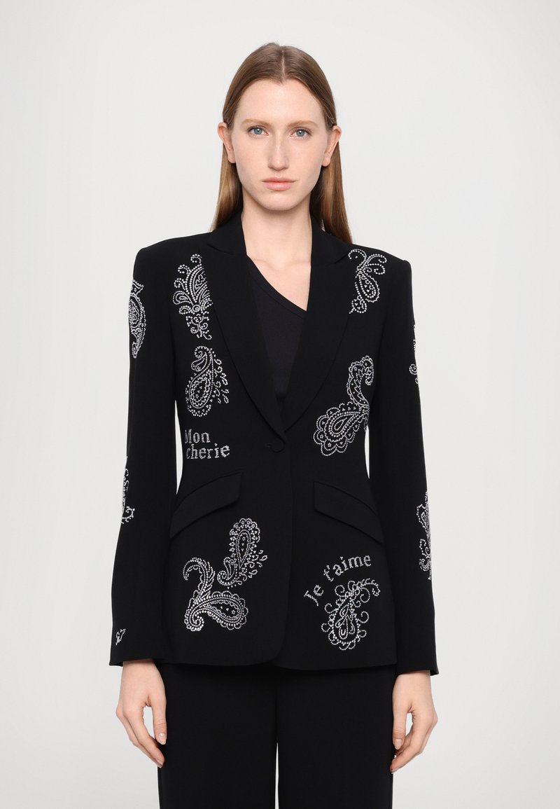 Černý blejzr s korálkovými a výšivkovými detaily v paisley vzoru s nápisy "Mon chérie" a "Je t'aime." Díky přiléhavému střihu a klopovému límci.