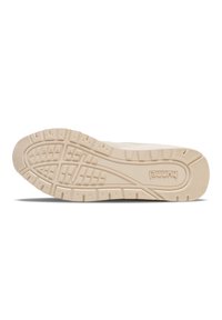 Hvit sneakersåle med teksturert gummi og et mønster av spor og forhøyninger for bedre grep. Merkenavnet "Hummel" preget på siden.