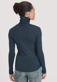 Dunkelblaues Langarm-Turtleneck-Oberteil mit taillierter Passform und weichem, elastischem Stoff. Verfügt über einen hohen Kragen und einen verlängerten Rücken.