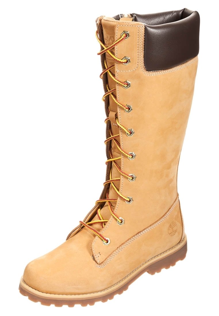 Bottes en daim beige hautes avec un revers en cuir marron, dotées de lacets jaunes et marron, d'œillets en métal et d'une semelle extérieure robuste pour une meilleure adhérence.
