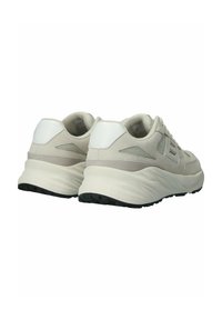 Světlé šedé tenisky s texturovaným textilem na svršku, bílými koženými akcenty a silnou gumovou podrážkou s vzorovaným dezénem.