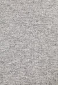 Grå texturerad tyg med en melerad mönster, som har en mjuk, slät yta och en konsekvent stickad struktur genom hela.