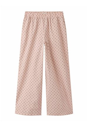 Világos rózsaszín, bő szárú nadrág fekete pöttyökkel és gumis derékkal, fehér háttéren fekve.