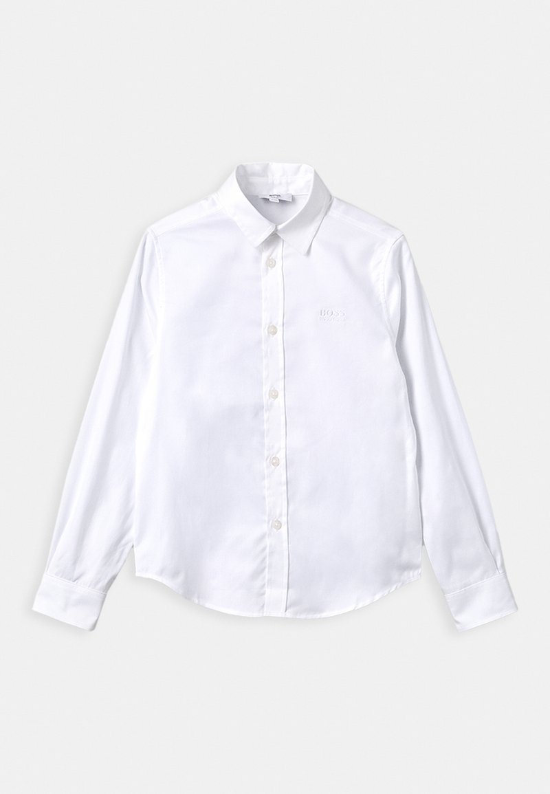 Bílá košile s dlouhým rukávem vyrobená z hladké látky, s špičatým límcem, zapínáním na knoflíky a jemným vyšitým logem na hrudi.