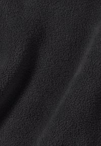 Tessuto in felpa nera con una superficie morbida e texture, caratterizzato da un motivo uniforme e un drappeggio fluido. Adatto per capi esterni o coperte.