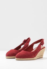 Rode suède wedge sandalen met een slingback ontwerp, voorzien van een enkelbandje en jute-wikkelde hakken. Glad textuur en ronde neusvorm.