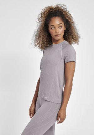 Kortærmet, lyse lilla træningsoverdel med struktureret stof, subtilt mønster og en afslappet pasform, parret med matchende leggings.