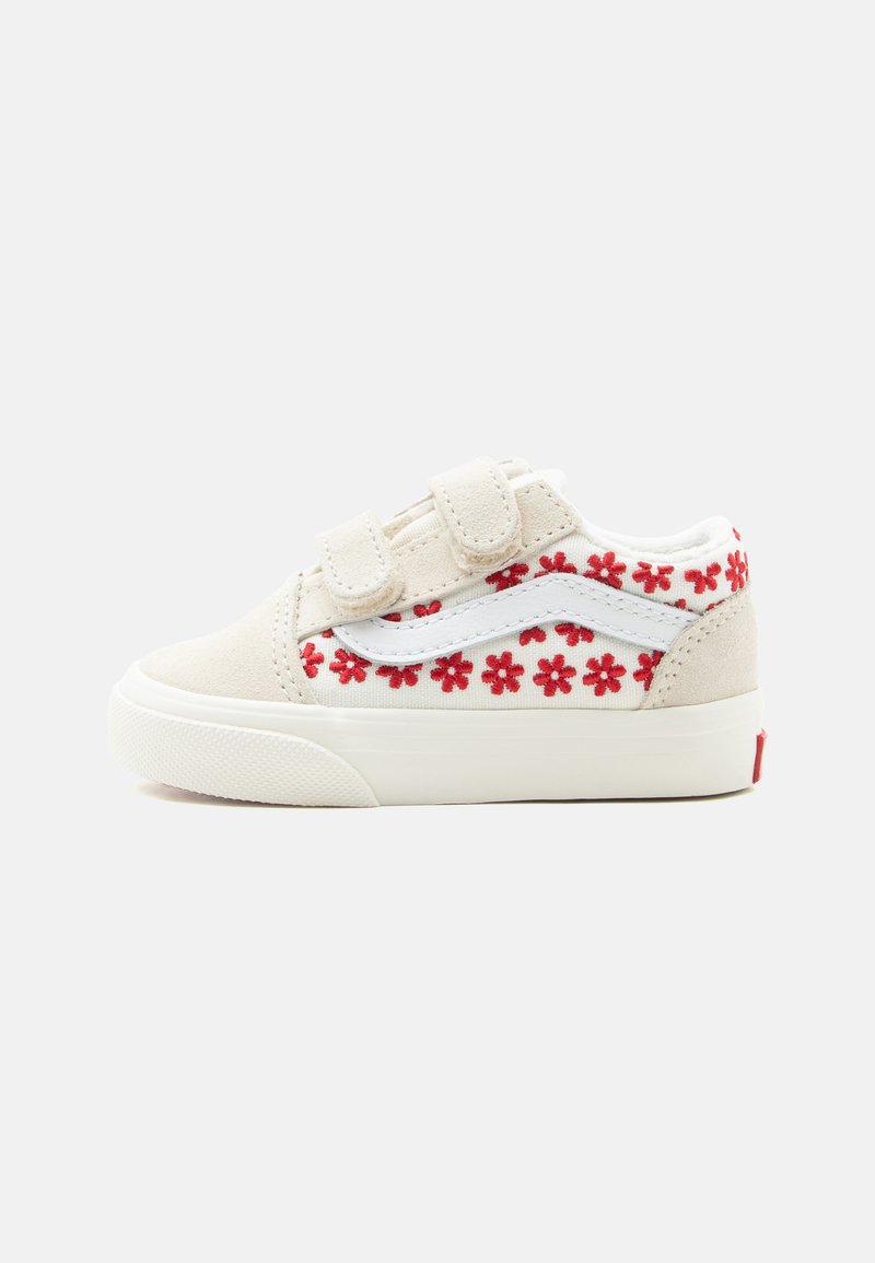 Baskets blanches pour enfants avec motif de fleurs rouges, bande latérale blanche et deux brides velcro sur fond uni.