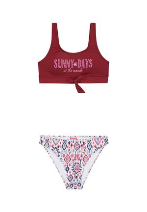 Haut de bikini sportif rouge avec imprimé "JOURS ENSOLEILLÉS au bord de la mer" et détail à liens. Le bas assorti arbore un motif géométrique coloré.