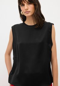 Top senza maniche nero realizzato in tessuto morbido, con scollo tondo e una vestibilità comoda, caratterizzato da cuciture minime e senza modelli visibili.
