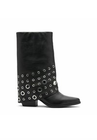 Bottine en cuir noir à forme cylindrique, ornée d'œillets en métal argenté disposés en motif le long de la section inférieure.