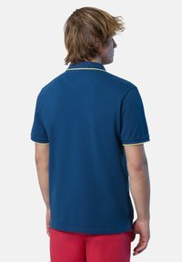 Polo in blu navy con maniche corte e colletto a costine con dettagli verde lime. Texture liscia e design classico.