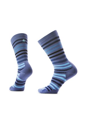 Et par blå skridstrømper med horisontale striber i forskellige nuancer af blå og sort, vist fra side- og bagvinkler på hvid baggrund.