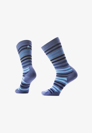 Par de calcetines de tripulación azules con rayas horizontales en varios tonos de azul y negro, mostrados en ángulos lateral y trasero sobre un fondo blanco.