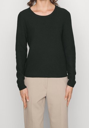 Maglione a maniche lunghe ribbed verde scuro con scollo rotondo, abbinato a pantaloni beige chiaro. Presenta una silhouette aderente e un tessuto testurizzato.