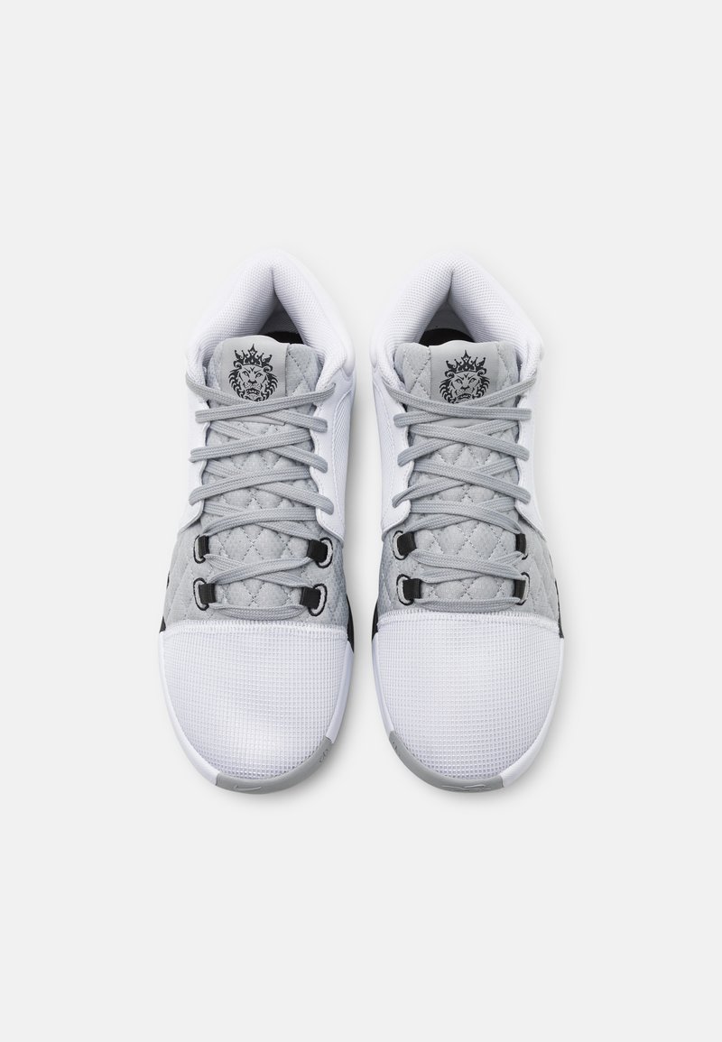 Zapatillas deportivas de cordones en gris y blanco. Cuentan con malla texturizada, paneles laterales acolchados y un acento negro. Gráfico de león en la lengüeta.