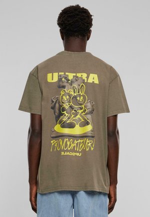 Olivengrøn bomulds t-shirt med et stort grafisk design på ryggen, der viser to tegneseriefigurer og fed tekst i neongul. Korte ærmer.