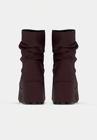 Μπορντό άνετες μποτάκια αστραγάλου με υφή, ψηλά τετράγωνα τακούνια και λεία μαύρη σόλα, με συγκεντρωμένο σχέδιο στο πάνω μέρος.