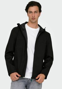 Giacca nera con cerniera e cappuccio, realizzata in tessuto liscio. Presenta due tasche frontali, cuciture minimali e un interno spazzolato per il calore.