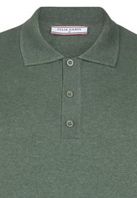 Mørkegrøn poloshirt med en struktureret krave, tre-knaps åbning og subtilt strikket stof. Labelen lyder "FELIX HARDY M."